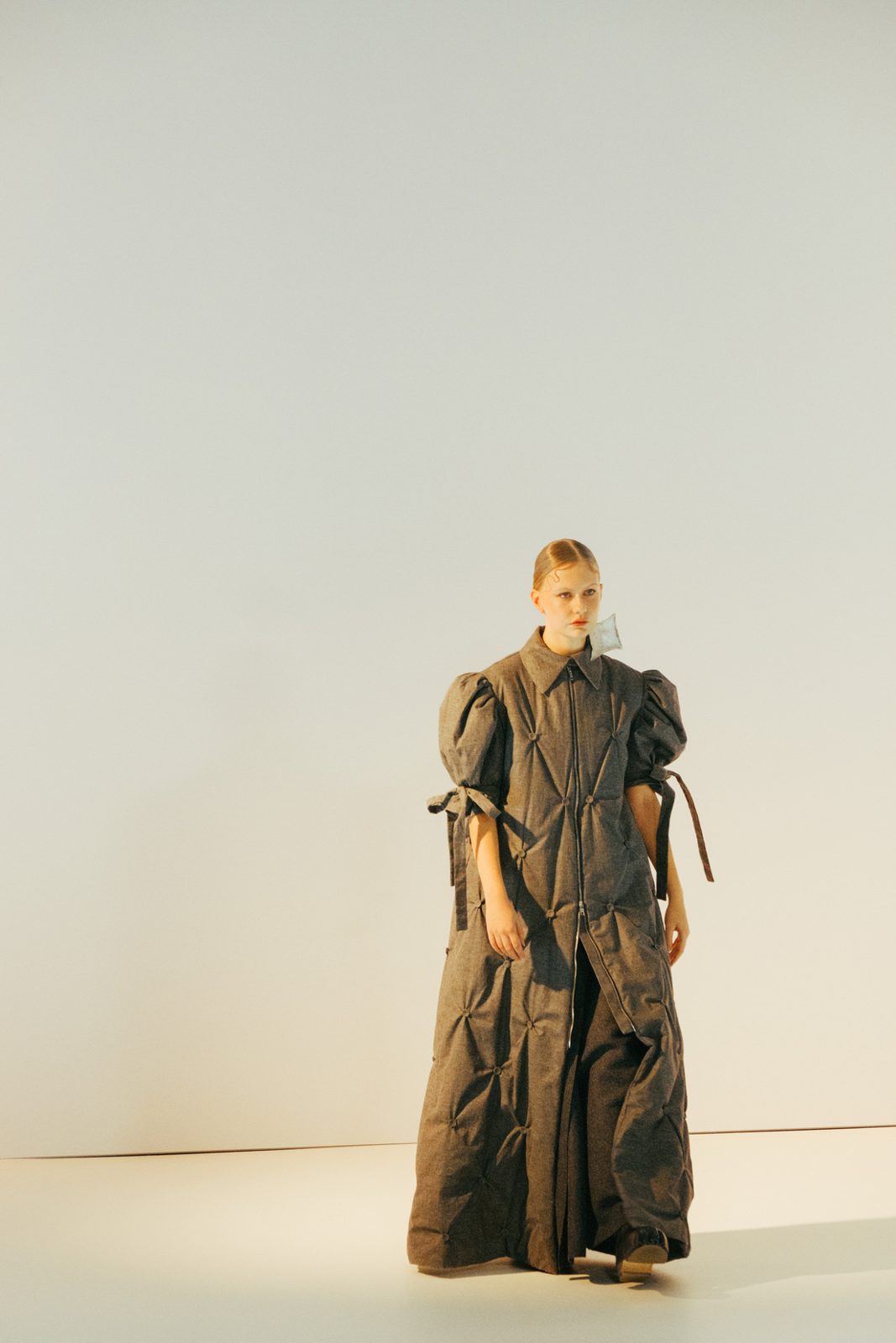 Model in a draped brown garment