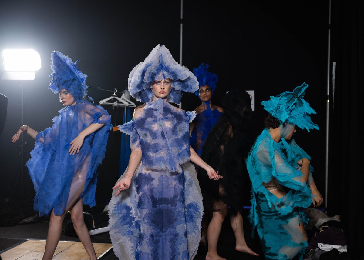 Performers in blue sculptural costumes
