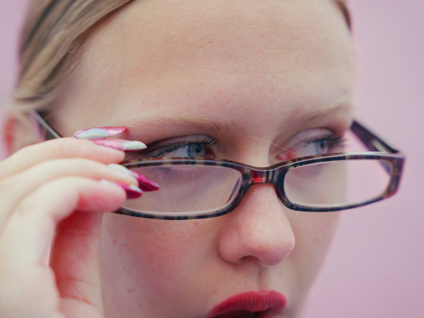 Close-up of a character adjusting her glasses